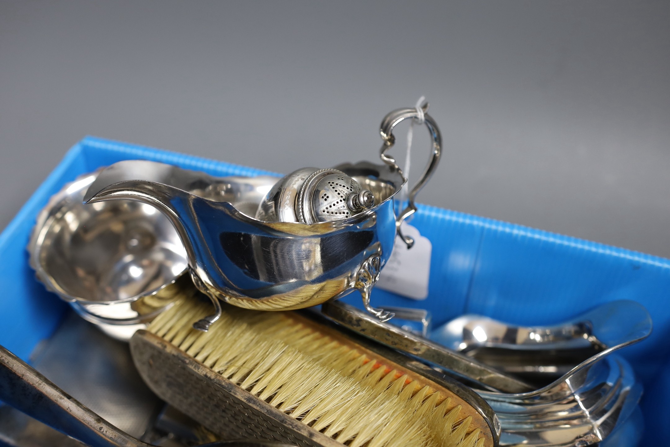 A collection of small silver including a repousse dressing tray, cream jug, sugar bowl, pepperette, sauceboat, two cigarette cases, compact, napkin ring and a mounted enamel mirror and brush set, weighable silver 41.5oz.